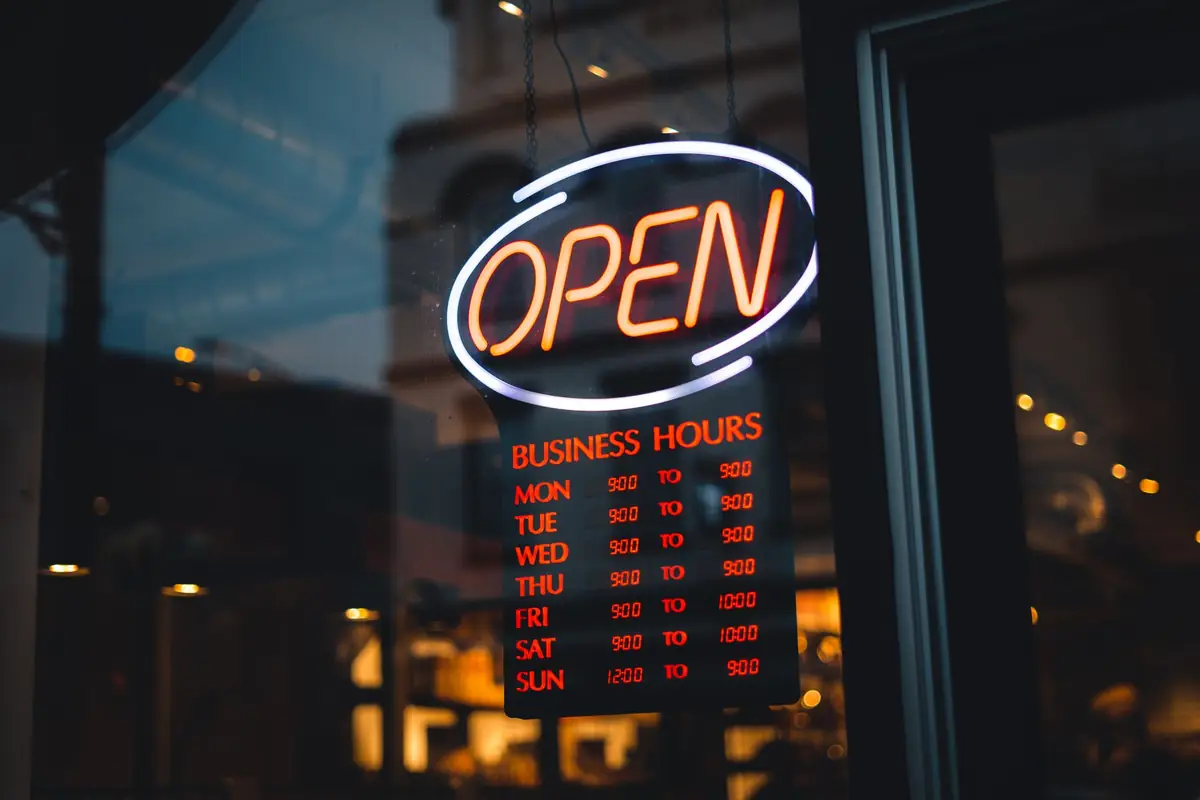 An illuminated open sign in a storefront window