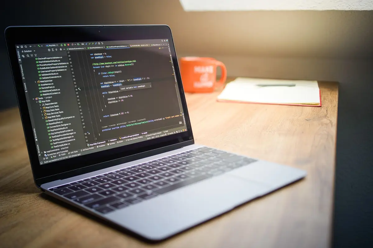 A laptop showing website code on a clean desk